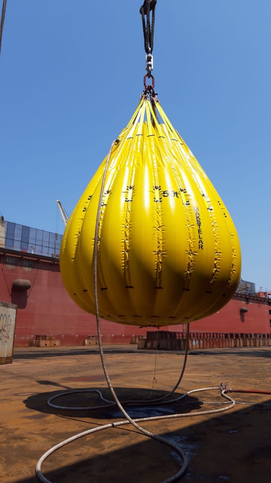 Water-bag test load suspended above a vessel deck