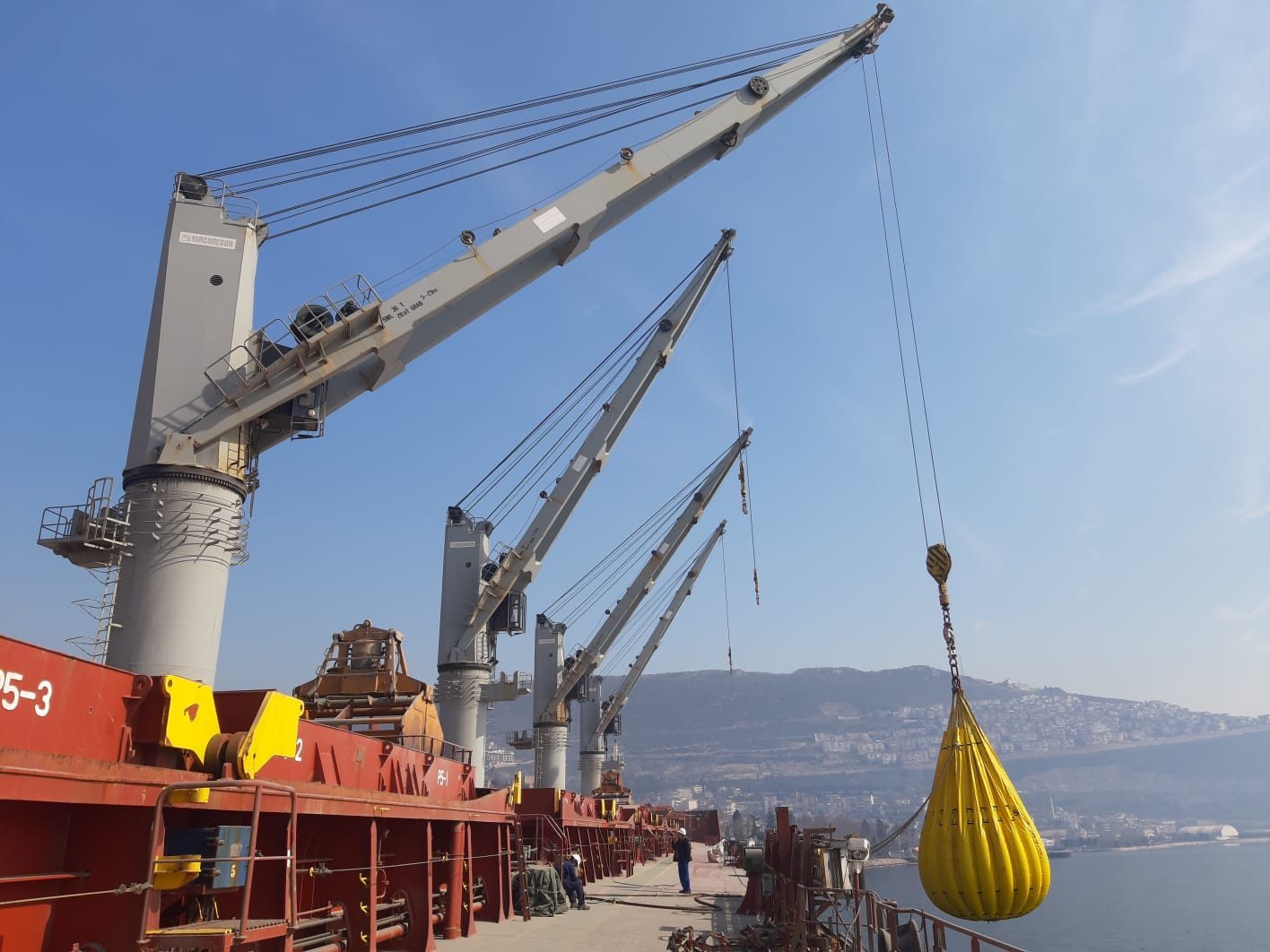 Shipboard crane carrying a water-bag test load
