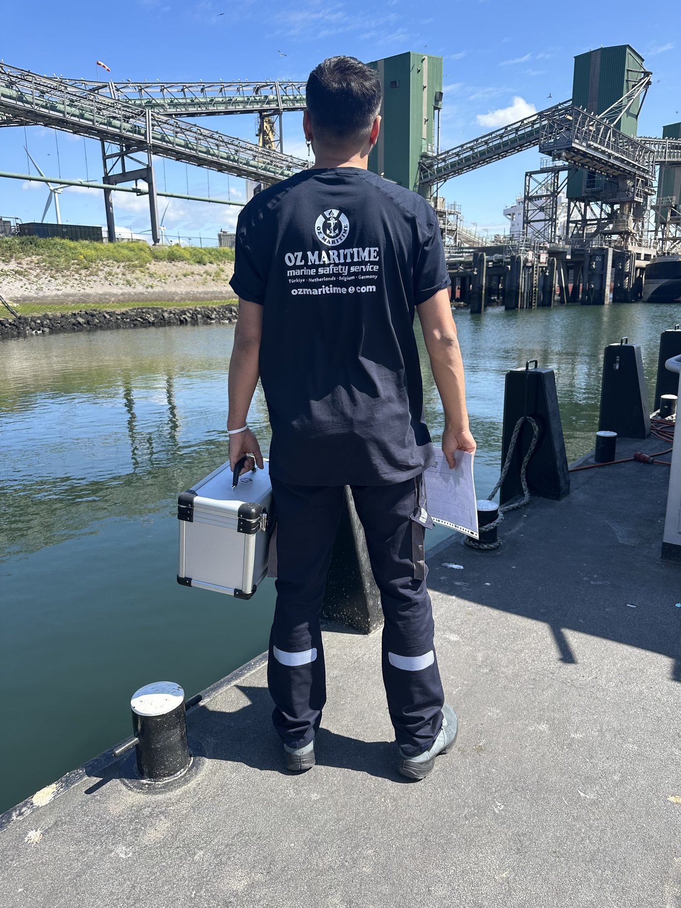 OZ Maritime technician carrying inspection equipment on board