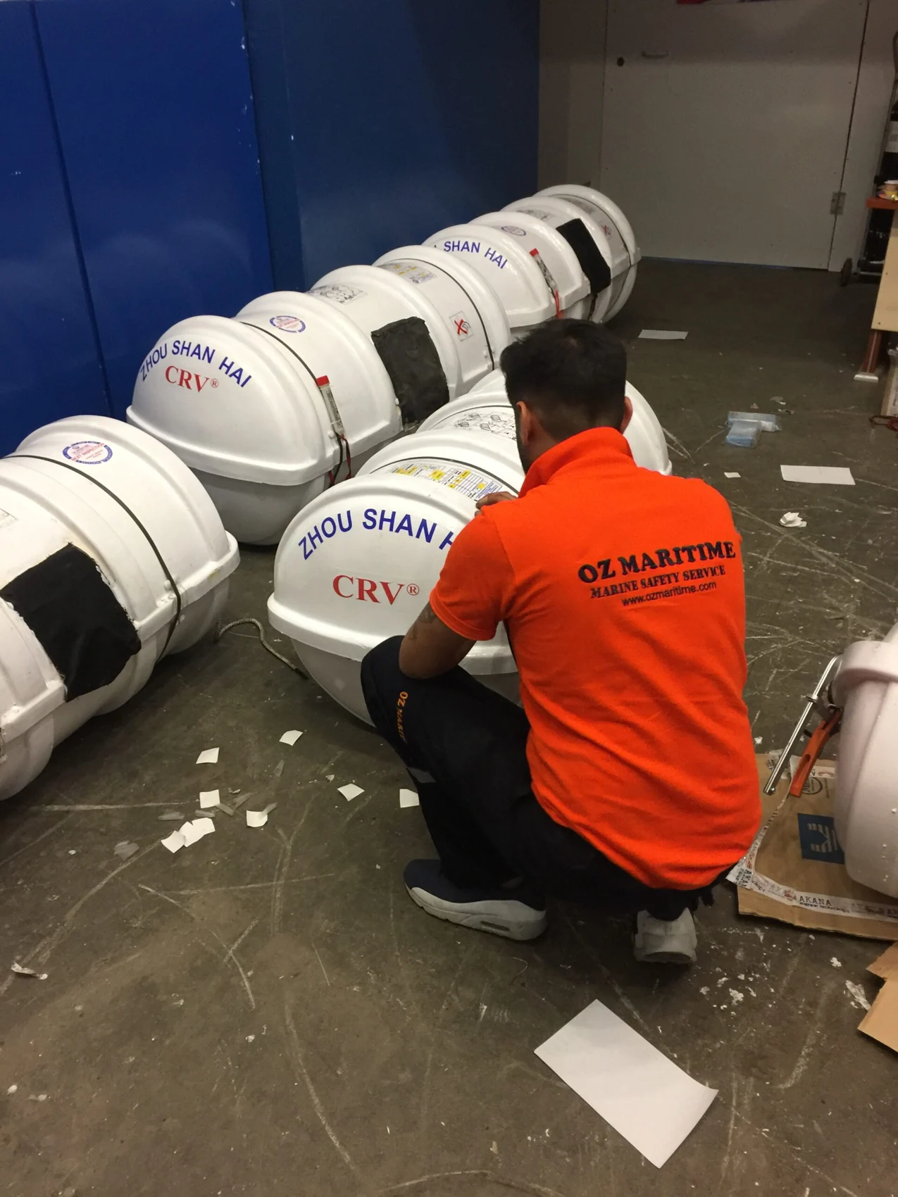 Technician preparing liferaft containers in the service station